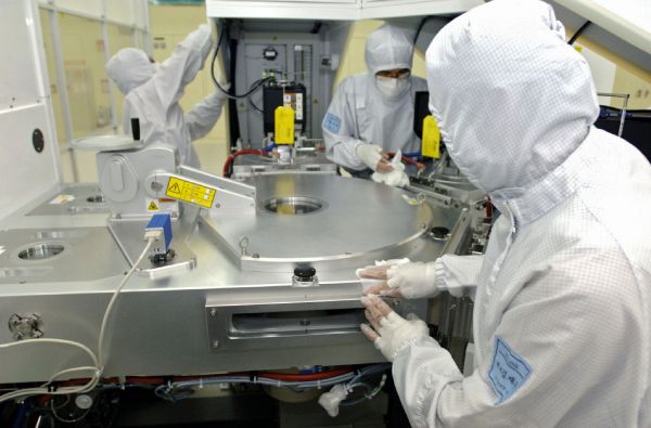  这张三星公司2007年8月6日发布的资料照片显示，工作人员在位于韩国水原的三星电子公司一个芯片厂擦拭装配线。（新华社/法新）